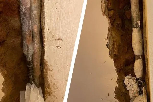 Plumber repairing pinhole leak inside drywall wall cavity in East Bench Salt Lake City home