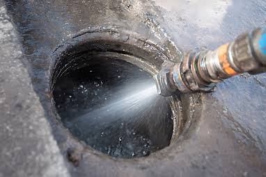 High pressure water nozzle spraying into sewer drain opening for deep line cleaning in Salt Lake City
