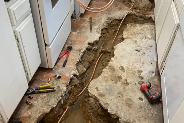 Excavated concrete slab trench in kitchen with new copper line routing for sub-slab leak repair in Salt Lake City